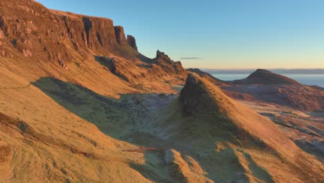 close flyby of landslip peak towards cliffs bathed in winter dawn light