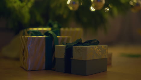 gifts under the christmas tree with green ribbon