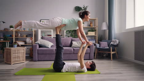 couple practicing acro yoga at home