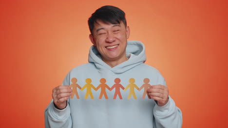 man showing multiracial different skin color human shape cut out of paper against racism community