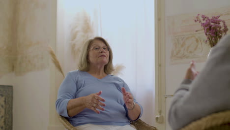 happy mature woman sitting in chair and talking with husband