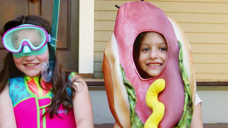 children in halloween costumes for trick or treating on steps