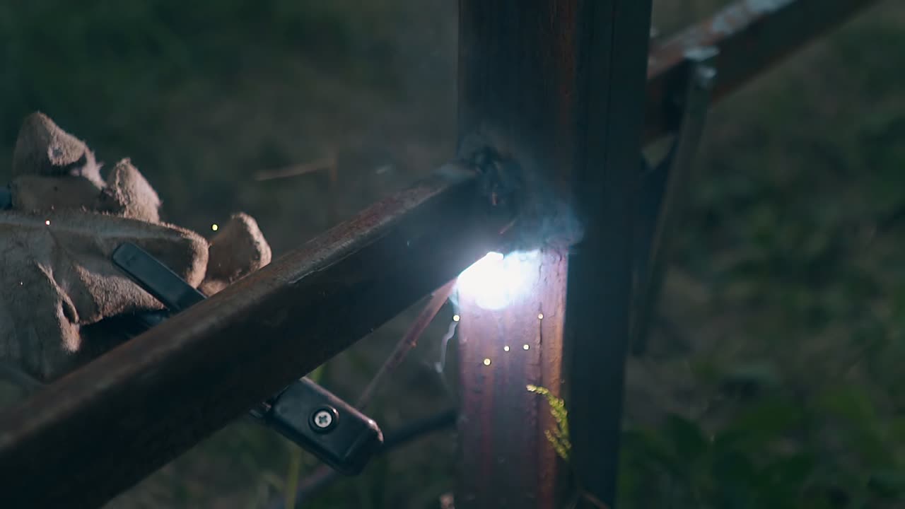 슬로우 모션 클로즈업 남자 가 용접 기계 로 울타리 를 짓고 있다