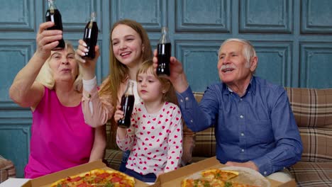 Glückliche-Mehrgenerationenfamilie,-Die-Zu-Hause-Eine-Mittagsparty-Veranstaltet,-Pizza-Isst-Und-Gemeinsam-Anstößt