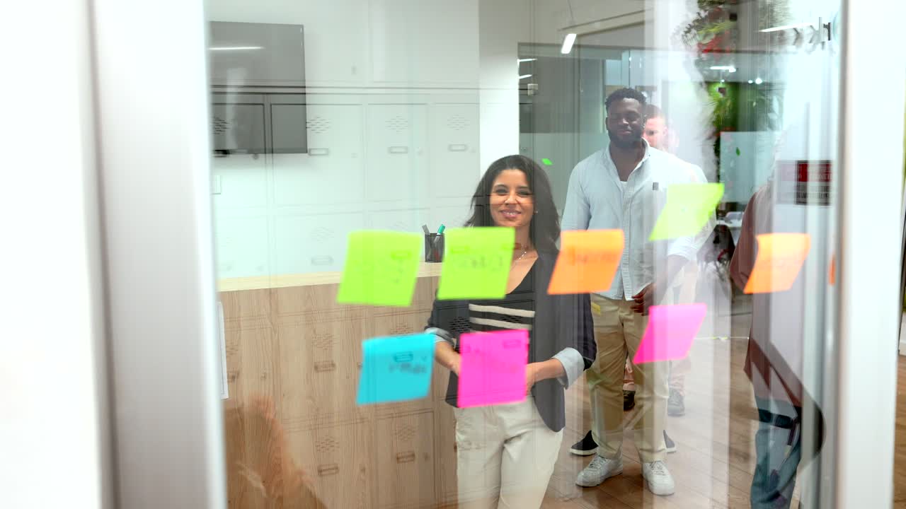 Team Brainstorming Session with Sticky Notes on Glass Wall