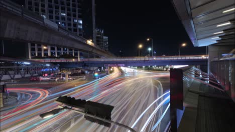 lapso de noche de larga exposición de una concurrida intersección en el puente japonés tailandés en bangkok, tailandia