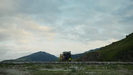 group of people near a car in the mountains