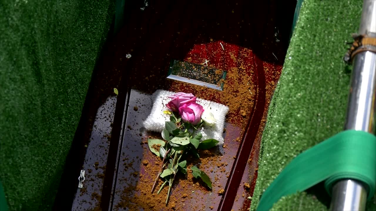 captura de pantalla de un ataúd funerario en un coche fúnebre o capilla o entierro en el cementerio
