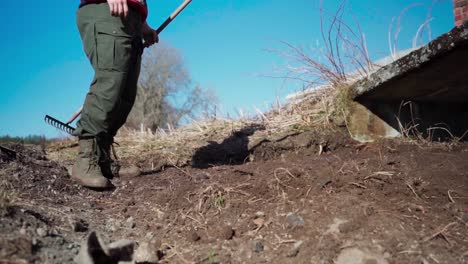 The-Man-is-Using-a-Rake-to-Smooth-and-Level-the-Soil-Before-Planting-on-the-Farm-in-Indre-Fosen,-Trondelag-County,-Norway---Timelapse