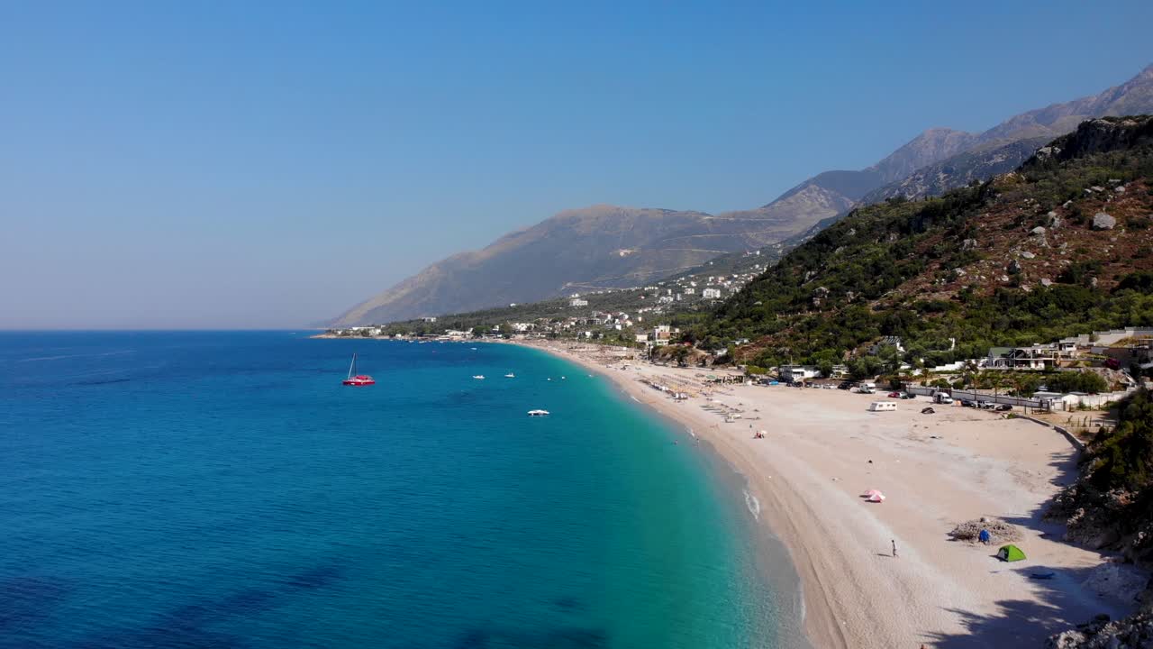 Unspoiled beach of Dhermi in Albania with sand and rocks washed by calm crystal azure sea water