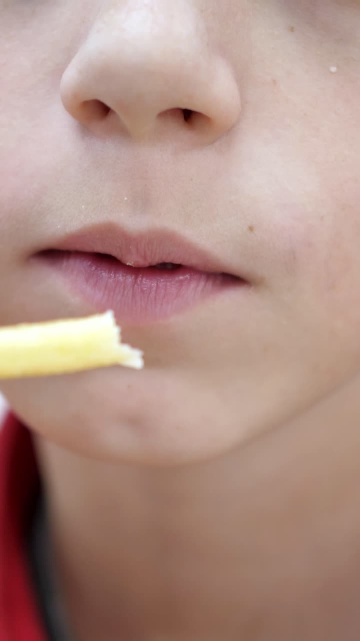 Close-up of young boy enjoying a snack, with a focused expression and soft lighting, capturing the essence of childhood delight and simple pleasures