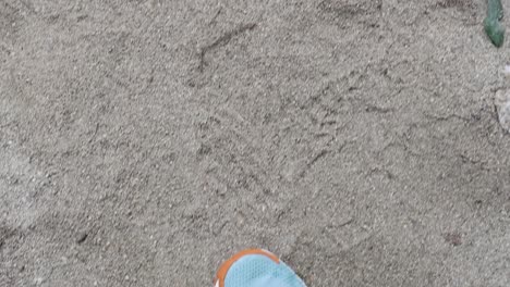 a person walks on sandy terrain in port douglas, queensland. the video captures steady footsteps with bright sneakers