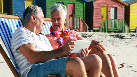 senior couple interacting with each other while using digital tablet