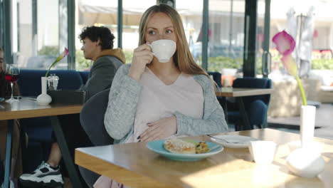 pregnant woman enjoying coffee and pastries in a cafe