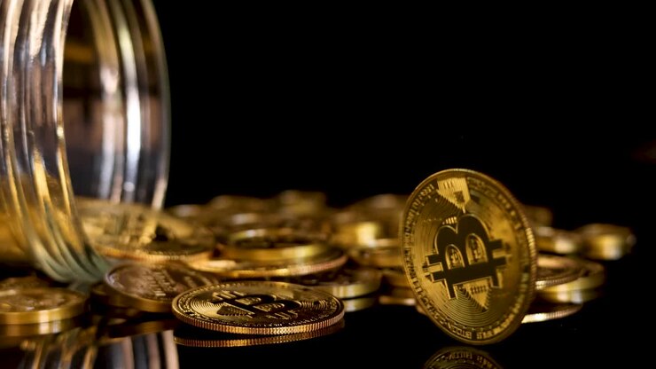 Moneta d'oro di criptovaluta che gira e si posa tra monete sparse, illuminazione drammatica, primo piano, telecamera statica