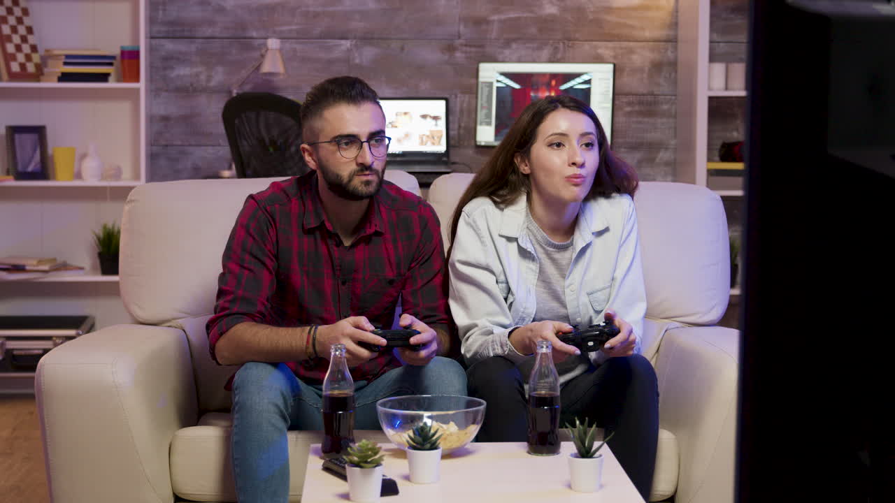 Couple playing video games at home
