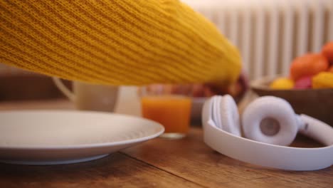 Woman&#039;s hand placing a croissant on breakfast place