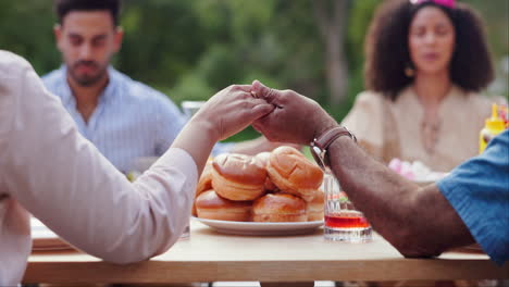 family prayer during outdoor meal