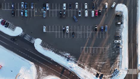 city parking, vehicles leaving the parking lot seen from above on a winter day