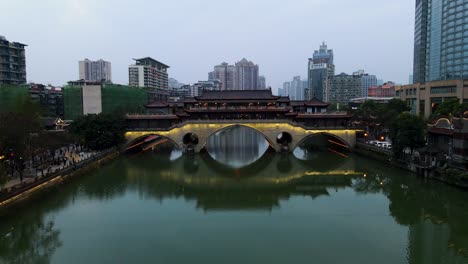 Anshun-Bridge-over-River-with-Downtown-Chengdu,-China-Skyline---Aerial