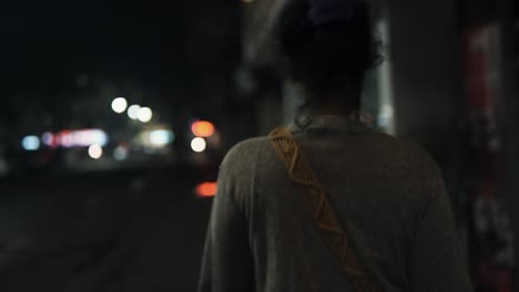 Street-at-night-ots-slow-motion-woman-walks-with-bokeh-lights-moving-cars-background