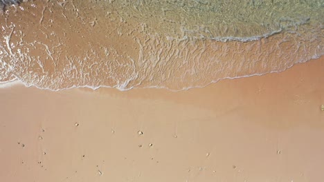 abstract sea waves and sandy beach background, golden sand, foamy waves of the turquoise sea