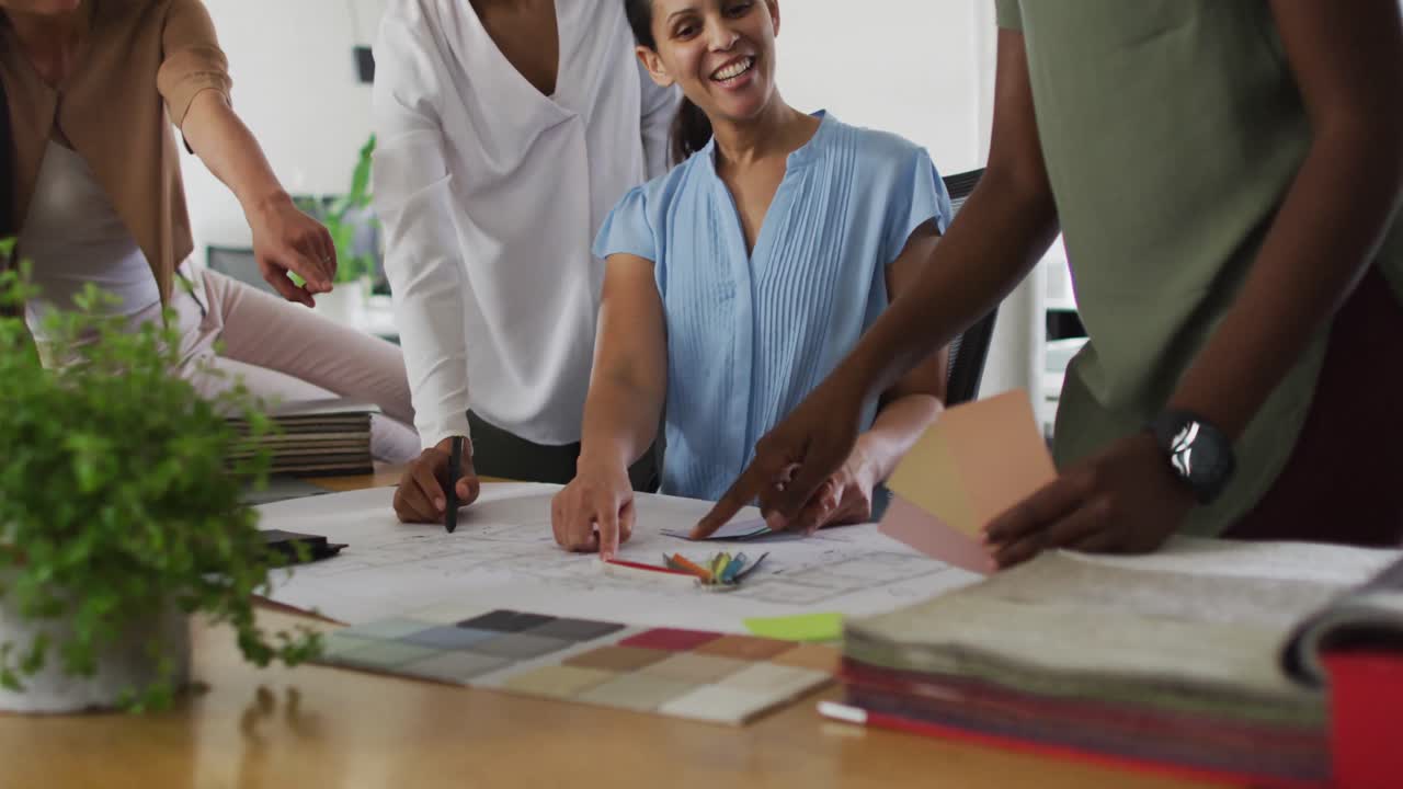 Midsection of group of happy diverse businesswomen working together in office
