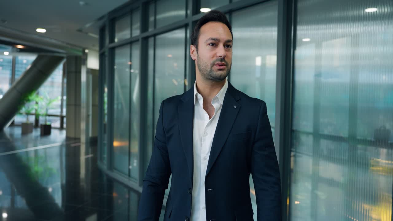Desperat ung leder gennemgår udskrevne dokumenter og gestikulerer udtryksfuldt, mens han holder dokumenter i en moderne virksomhedskontorglaskorridor - slowmotion dolly-indkørsel