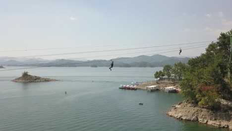 tourists enjoy zip line over picturesque xinanjiang reservoir in china