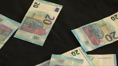 falling money in 20 euro banknotes on a black background