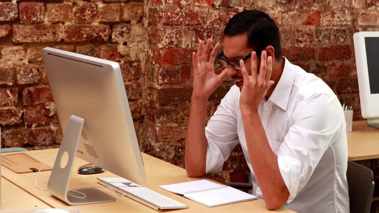Casual businessman getting stressed out at his desk