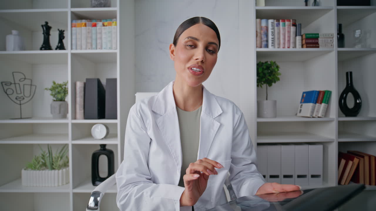 Healthcare practitioner consulting webcam in clinic closeup. Woman doctor call