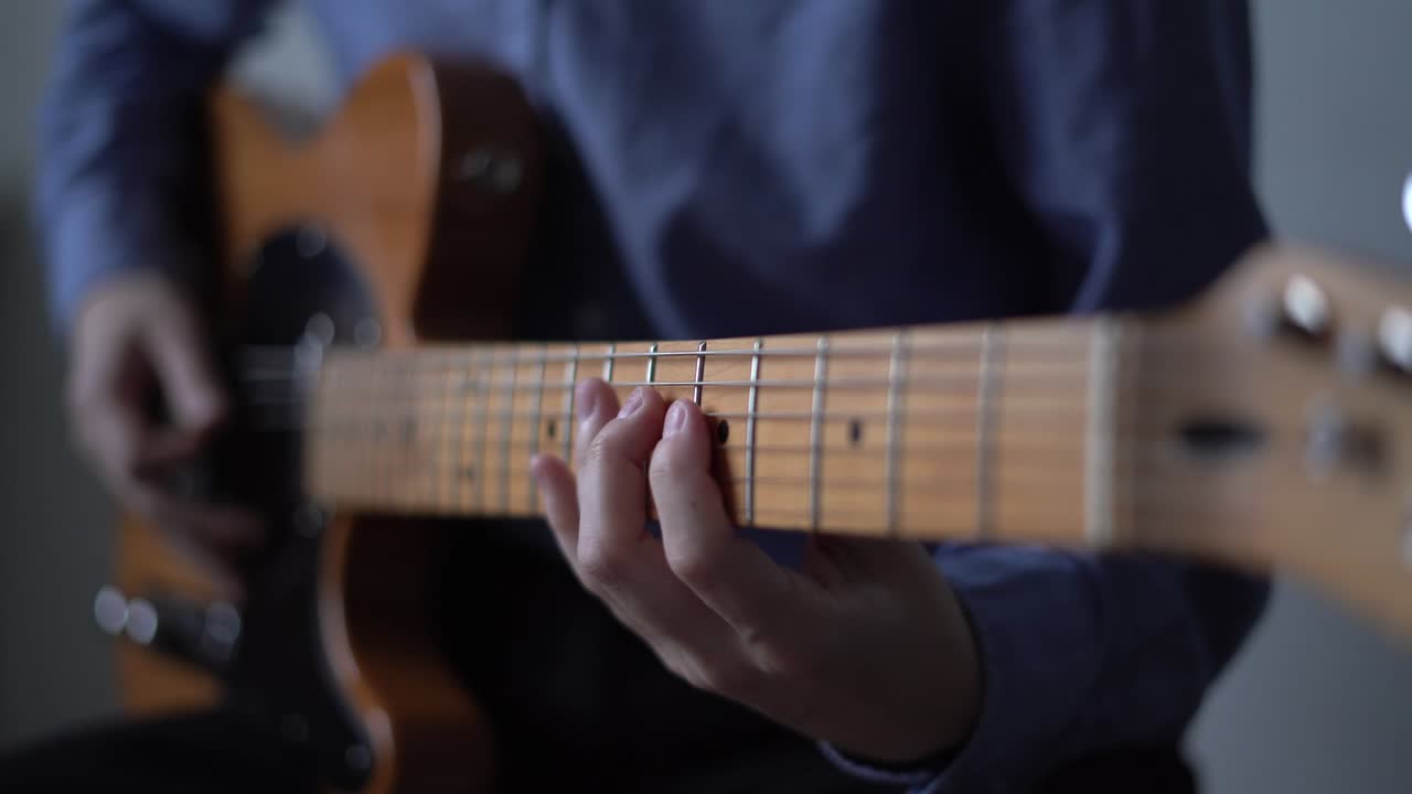 Bedroom producer playing a solo on electric guitar, online course