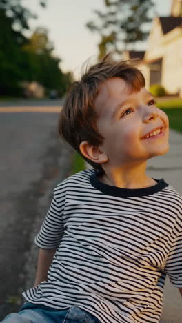 joyful young boy looking up outdoors at golden hour