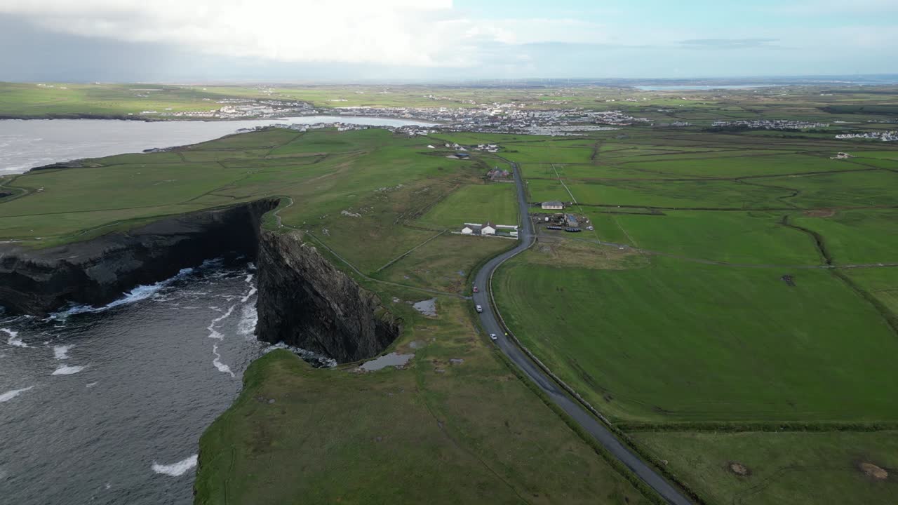 초록색, 휘어지는 도로, 그리고 작은 정착촌이 있는 거친 해안선