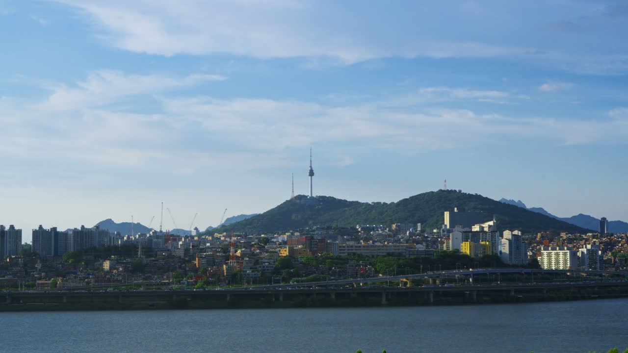 Wide shot of the Seoul city skyline featuring Namsan Tower and the Yongsan district with the Han River and a large blue sky for copy space