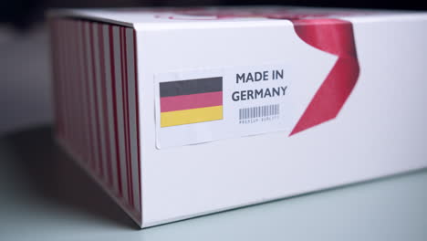 hands applying made in germany flag label on a shipping cardboard box with products