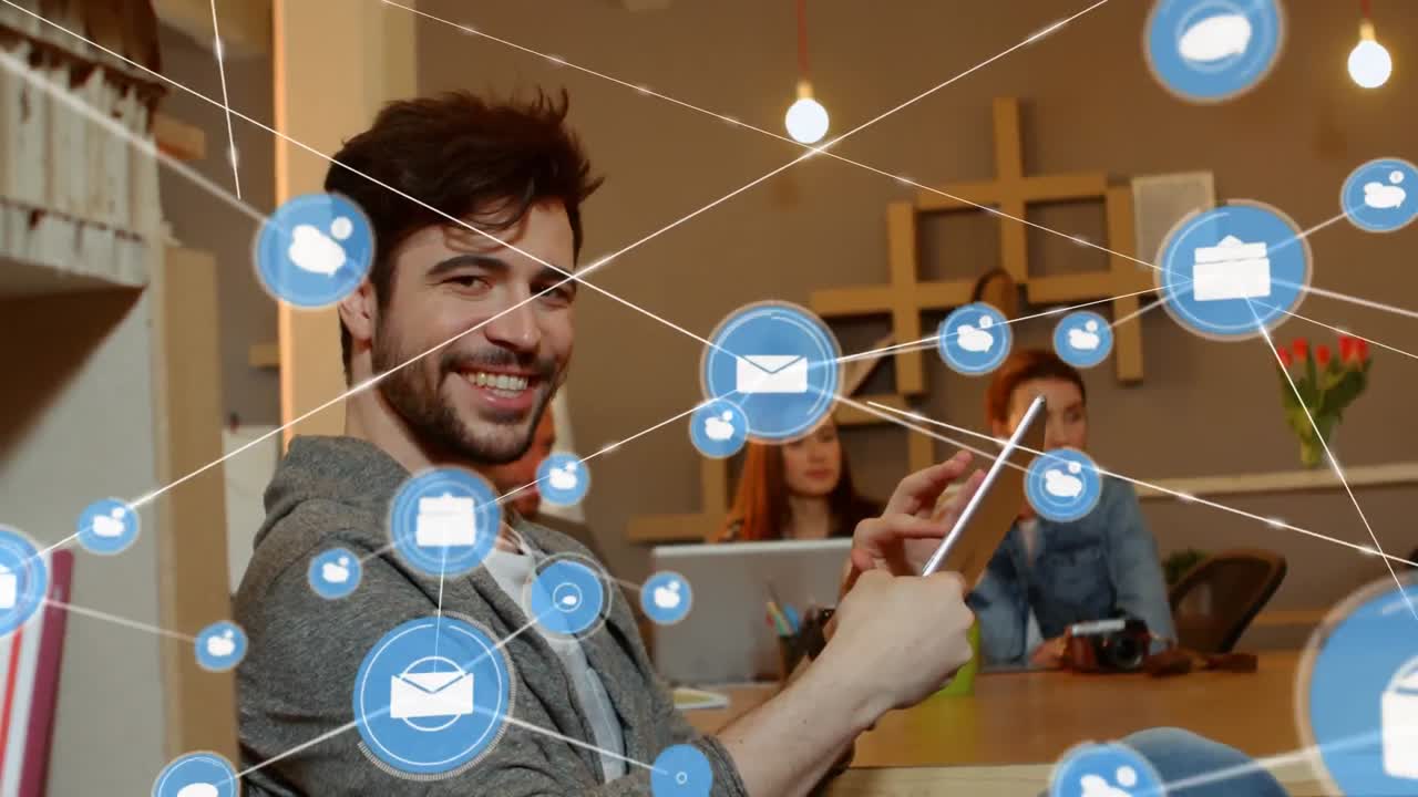 animación de una red de iconos digitales sobre el retrato de un hombre caucásico feliz usando una tableta en la oficina