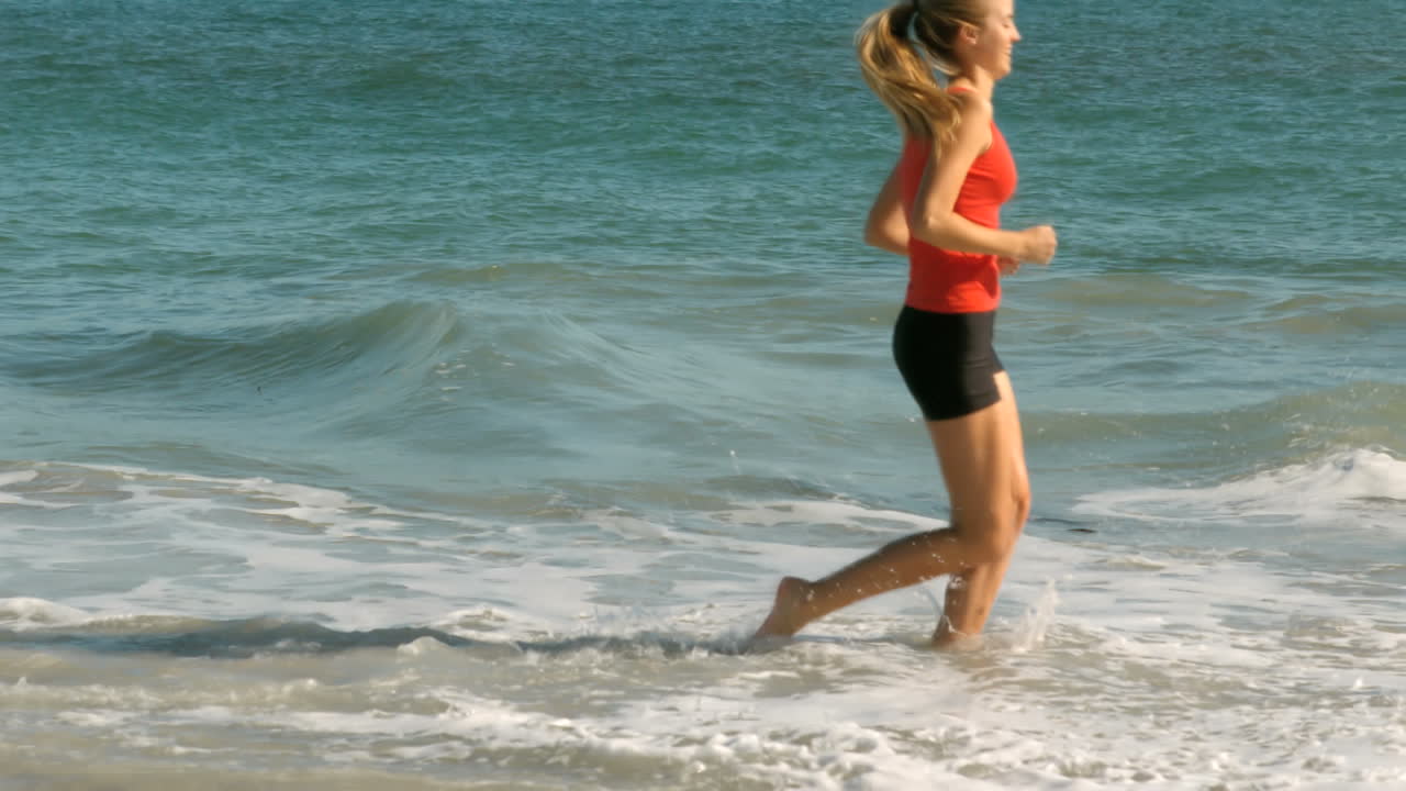 mujer feliz corriendo hacia el mar