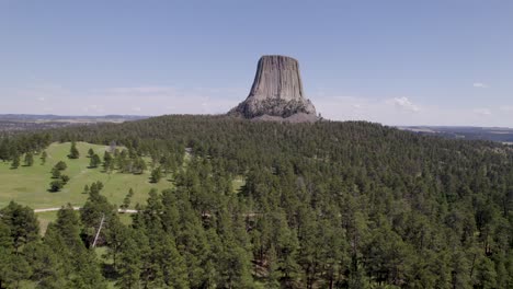 A-drone-shot-of-Devils-Tower,-a-massive,-monolithic,-volcanic-stout-tower,-or-butte,-located-in-the-Black-Hills-region-of-Wyoming