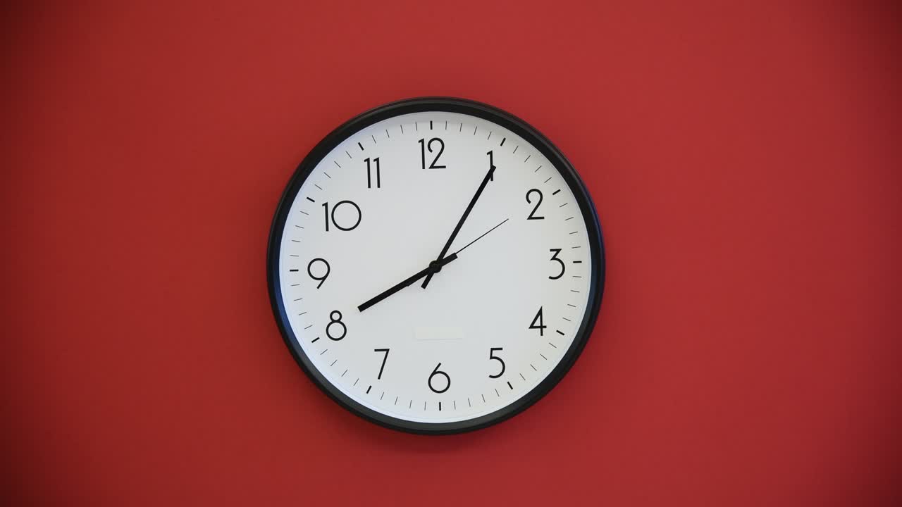 Black wall clock on red background