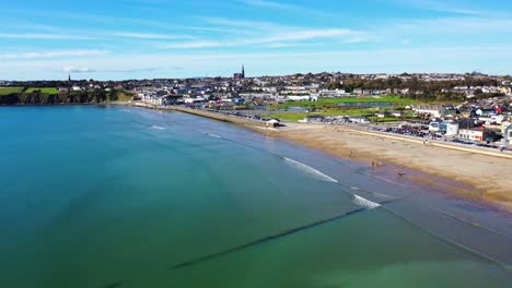 aerial tracking shot of tramore beach in ireland during beautiful sunny day