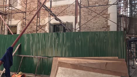 worker removing planks from metal scaffolding