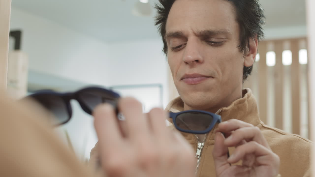 hombre probando gafas de sol en una tienda de ropa