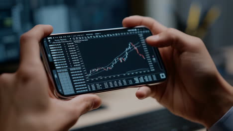 hands holding a smartphone displaying stock market data