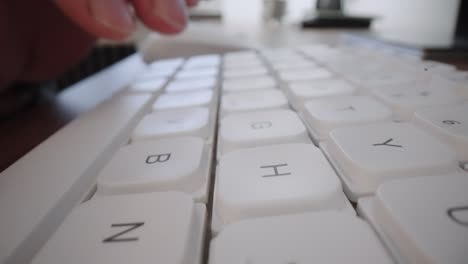 close-up moving macro shot: man hands typing on laptop keyboard working on internet project at light workplace. online content. digital marketing. business intelligence. digital analytics.