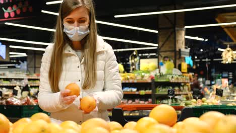 young woman buys oranges at the fruit market. ripe sweet fruits. natural vitamin c