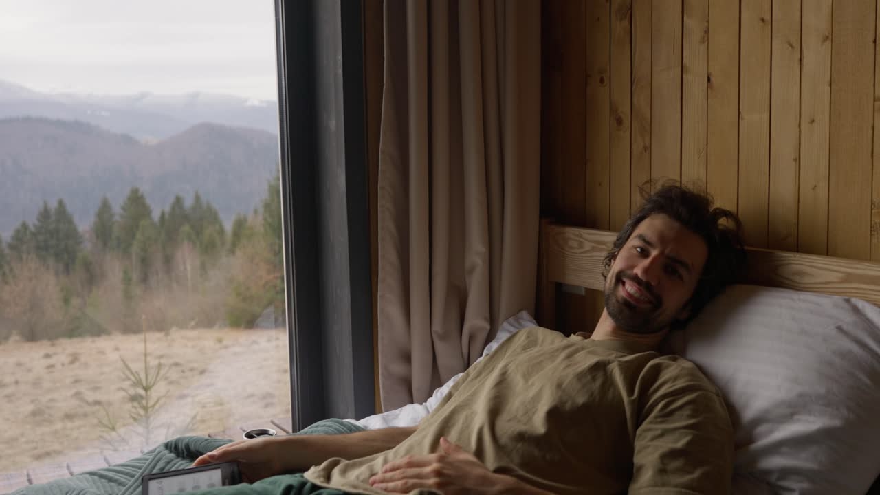 Man relaxing in bed with mountain view