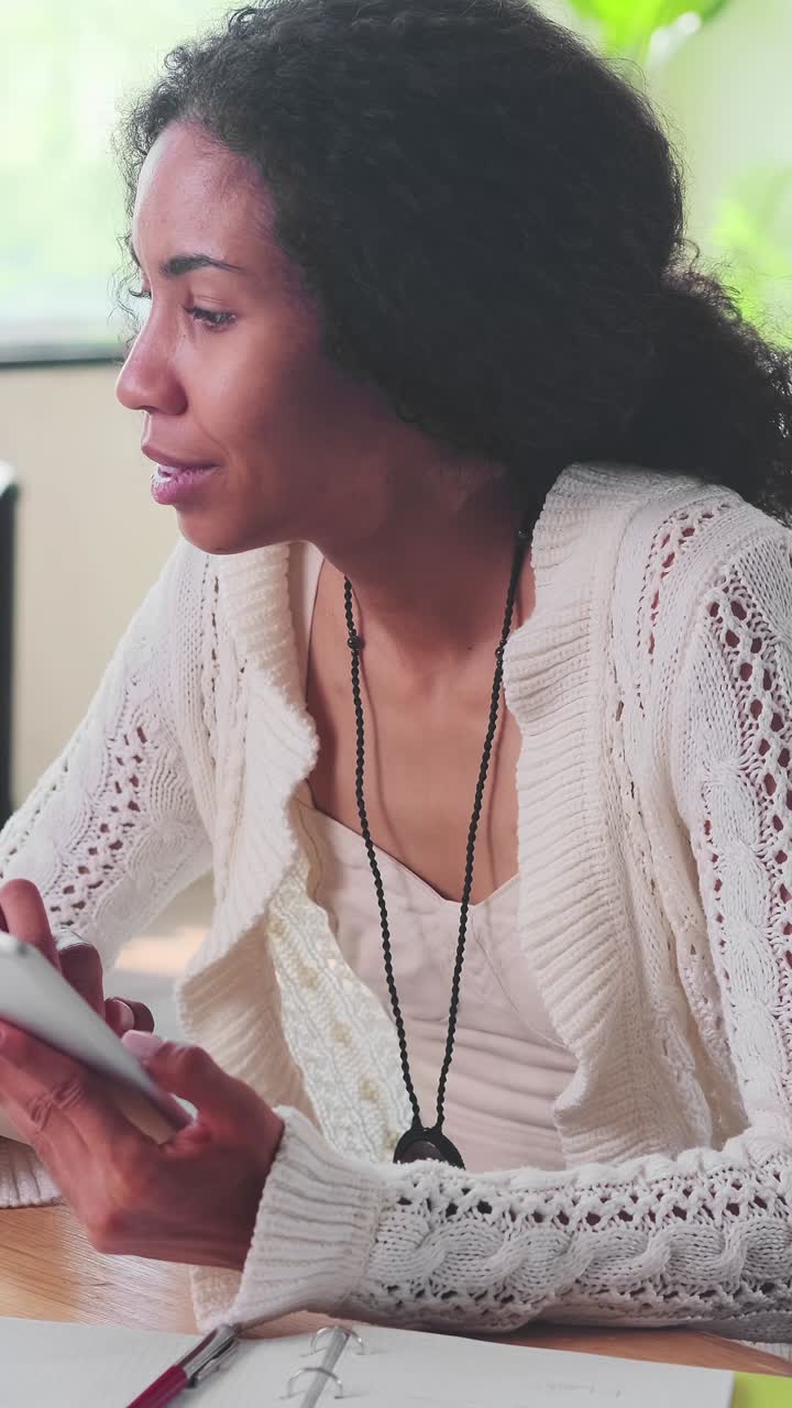 Young african american woman using gadgets for online shopping sits in office