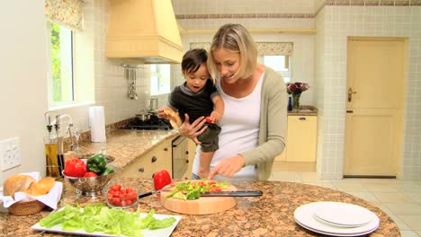 bebé ayudando a la madre en la cocina